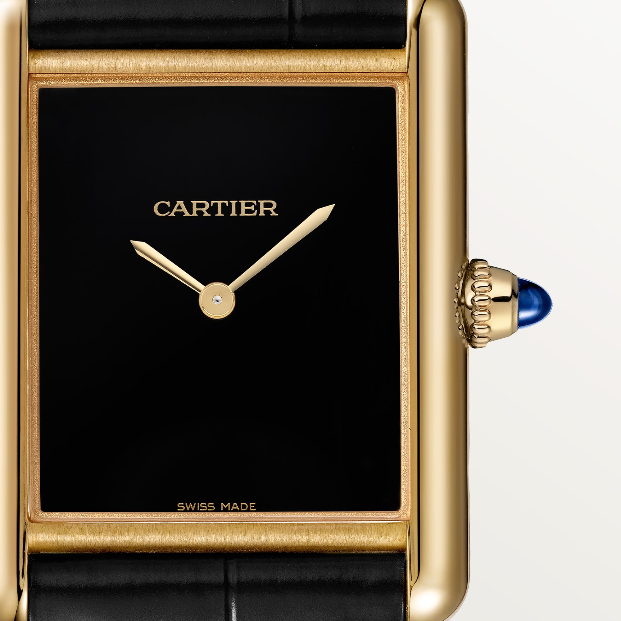 Macro shot of the black dial on a Dupe Tank Louis Cartier large model watch with a yellow gold color case, showing gold hands and the crown.