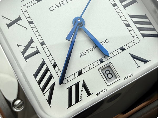 Close-up view of the Santos de Cartier watch dial from BVF Factory, showcasing the matte textured dial, raised print markers, and heat-blued steel hands with their characteristic color shift.