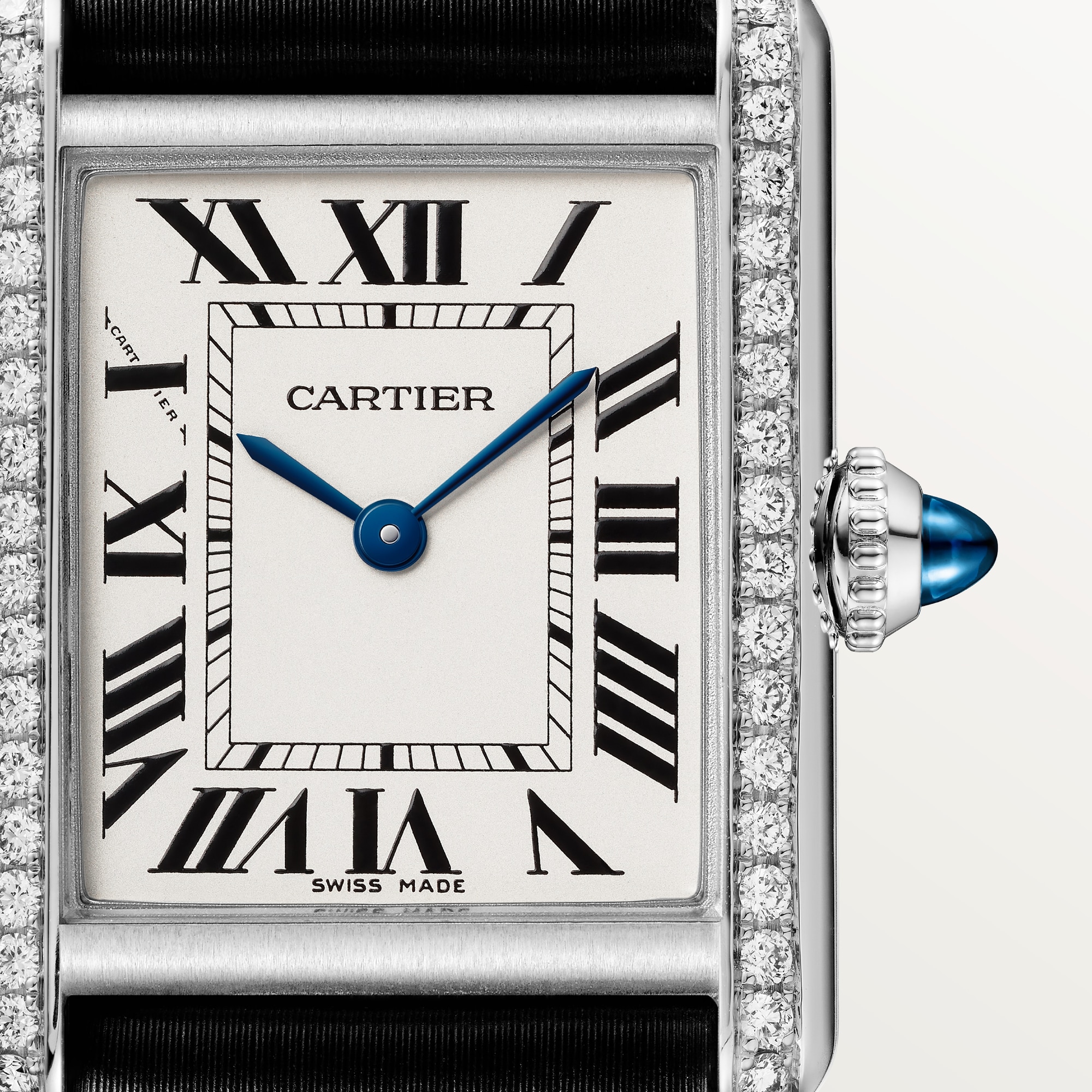 Close-up of the dial on a Dupe Tank Must de Cartier small model watch, showing Roman numerals, blue hands, and the diamond-set case and crown.