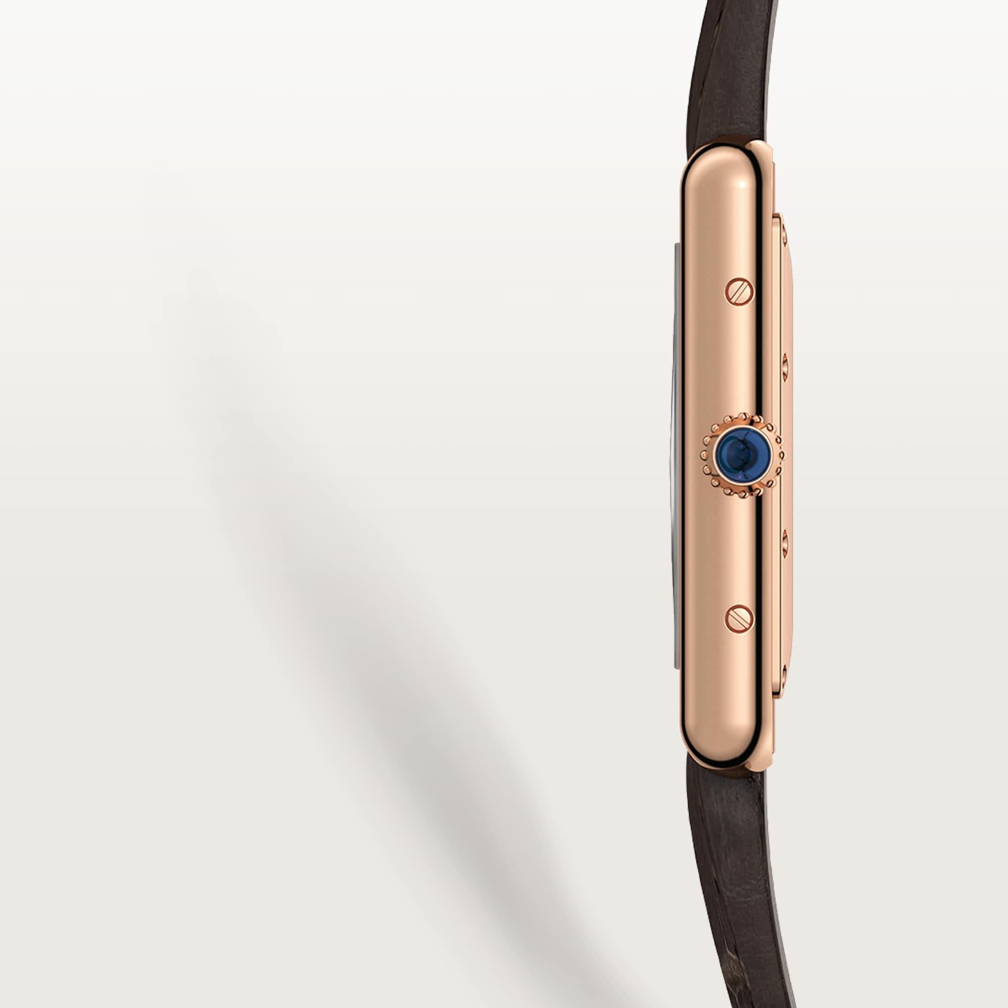 Close-up side view of a Dupe Tank Louis Cartier large model watch, showcasing the rose gold color case and blue spinel crown.