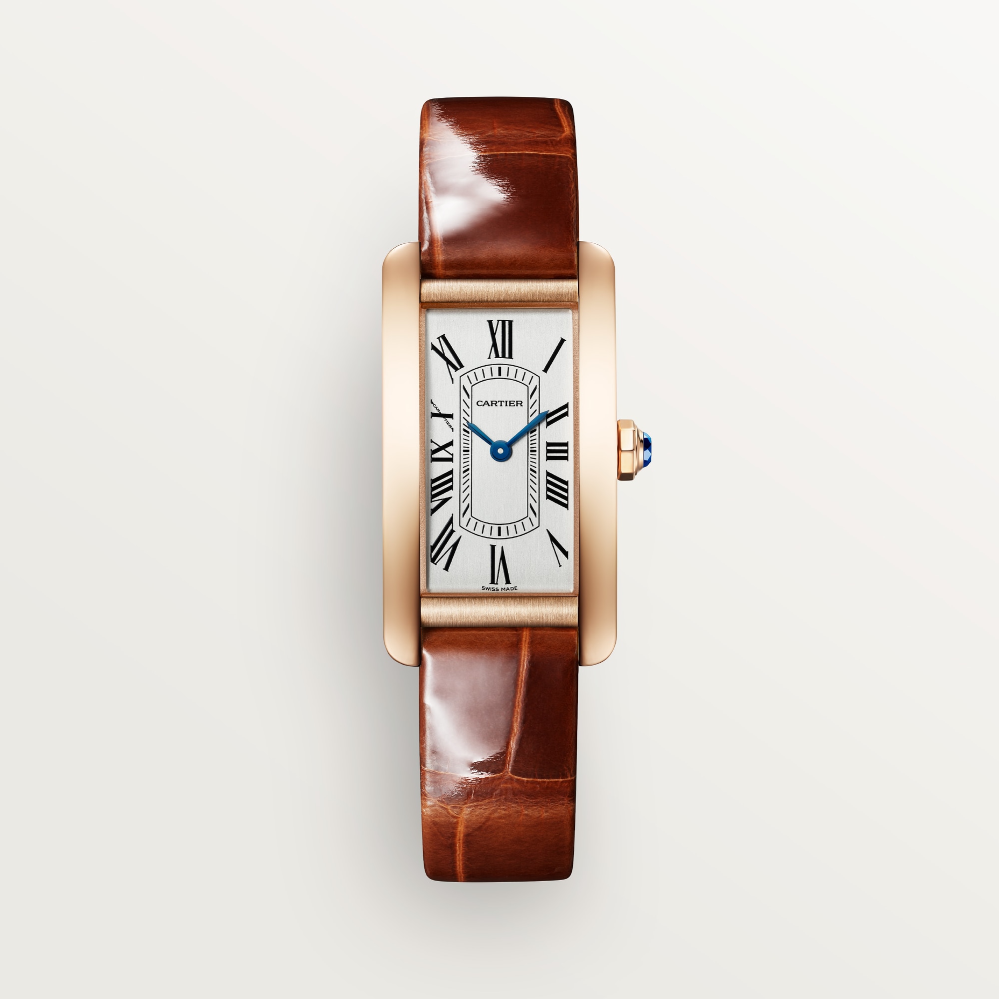 Front view of a Dupe Tank Américaine small model watch with a rose gold colors curved case, silver-white dial, and brown leather strap.