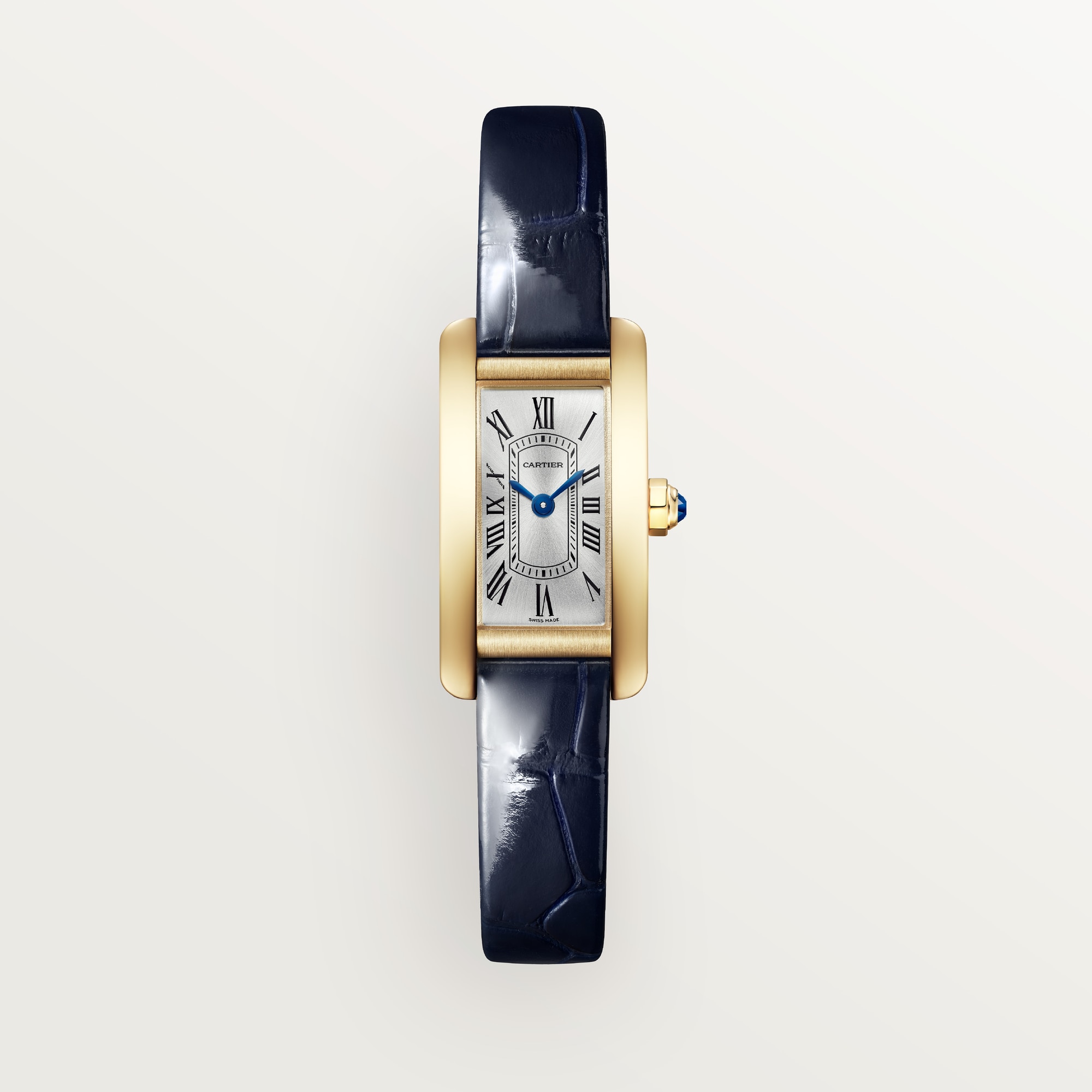 Front view: Dupe Tank Américaine mini model watch, yellow gold colors curved case, white dial, and blue patent leather strap.