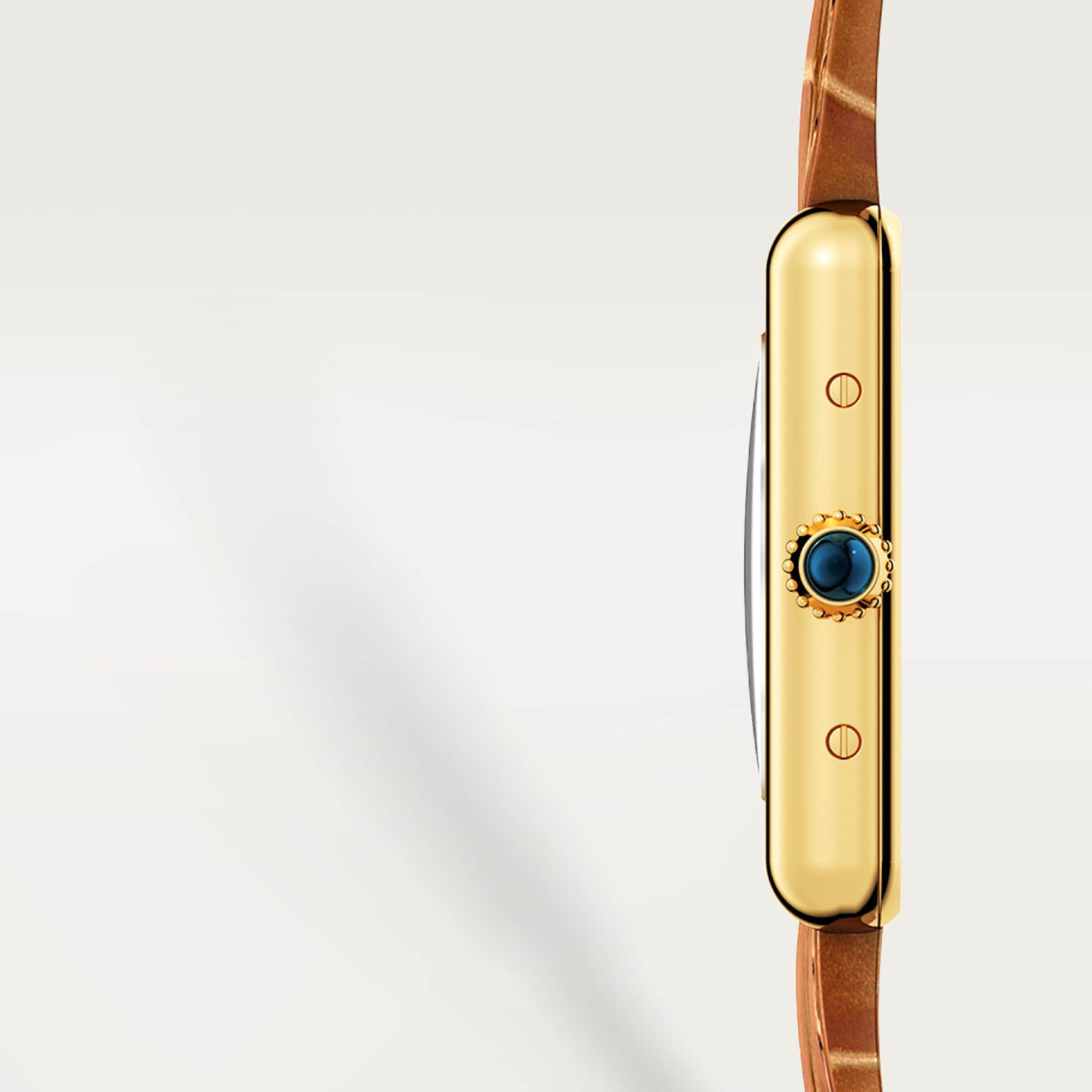 Crown detail: Side close-up of Dupe Tank Louis Cartier small model yellow gold colors watch, highlighting the blue spinel crown.