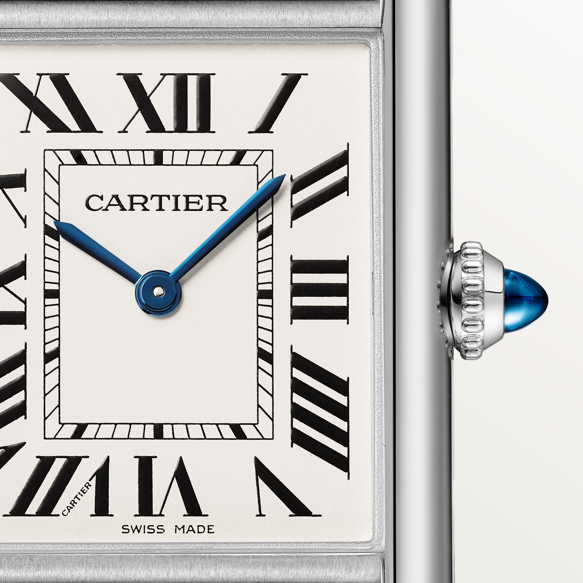 Close-up of the white Roman numeral dial on a large Tank Must dupe Cartier watch, steel case, with blue hands.