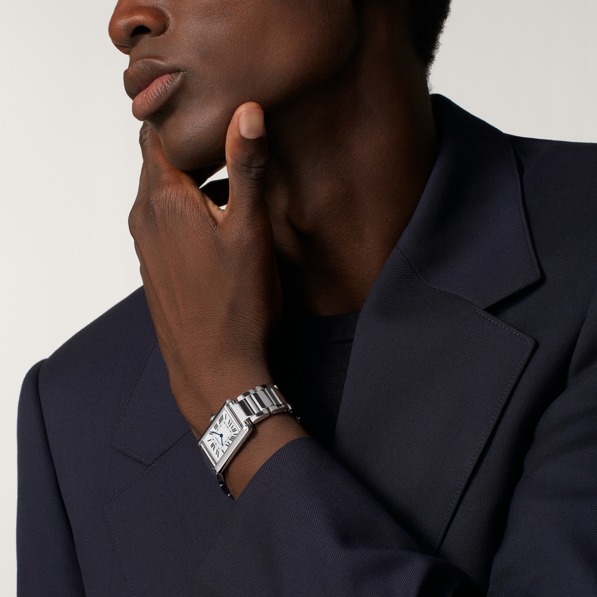 Man's wrist wearing the small Tank Must Solarbeat™ dupe Cartier watch with a full steel design.