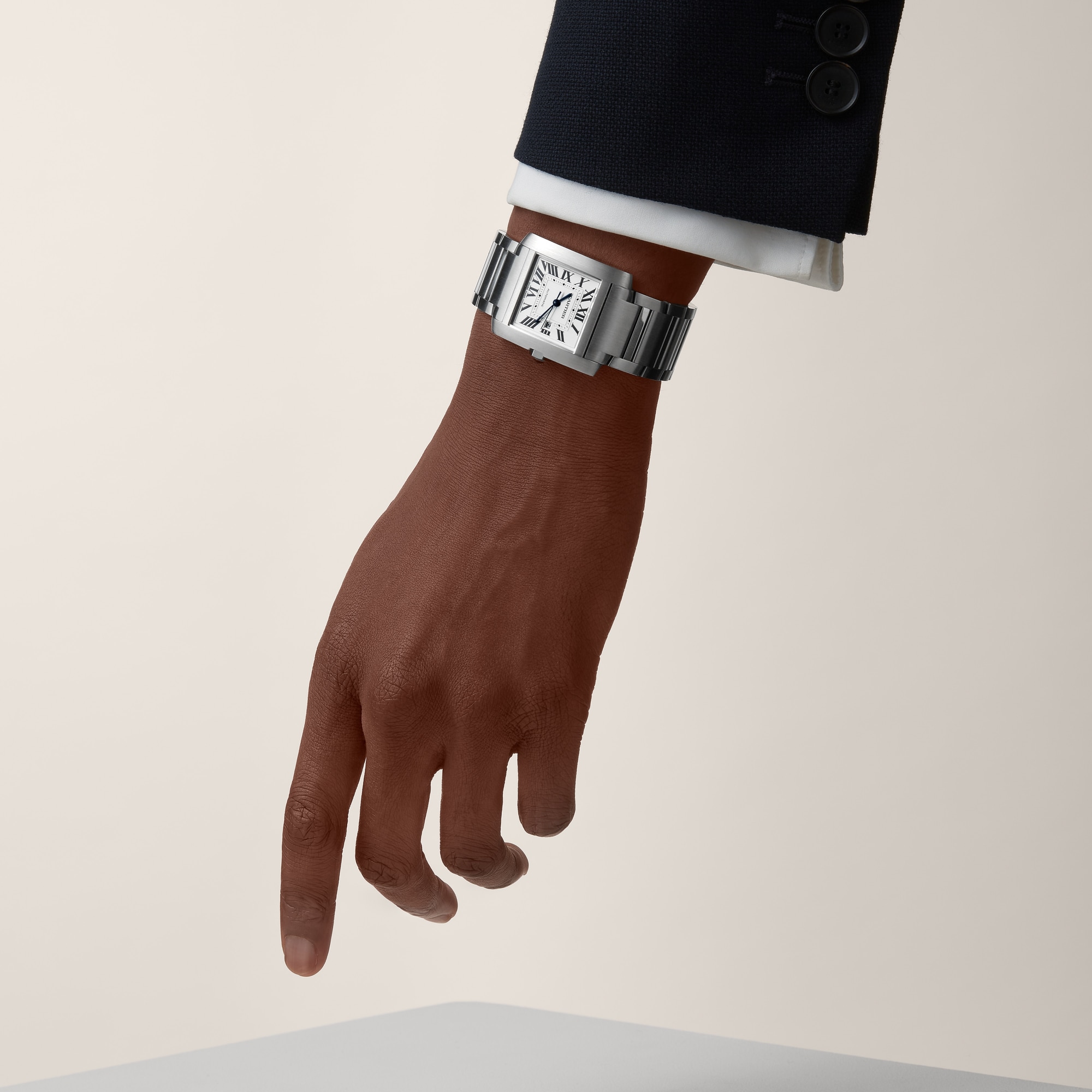 On wrist (formal): Stylish Dupe Tank Française large model watch with steel case, bracelet, and date display, worn by a male model in formal attire.