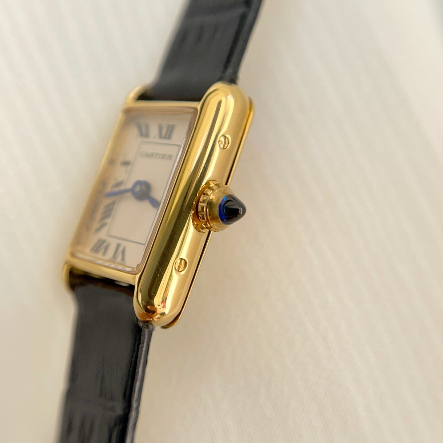 Close-up of the crown on the AF Super Clone Cartier Tank Louis replica watch, featuring the iconic blue gemstone.