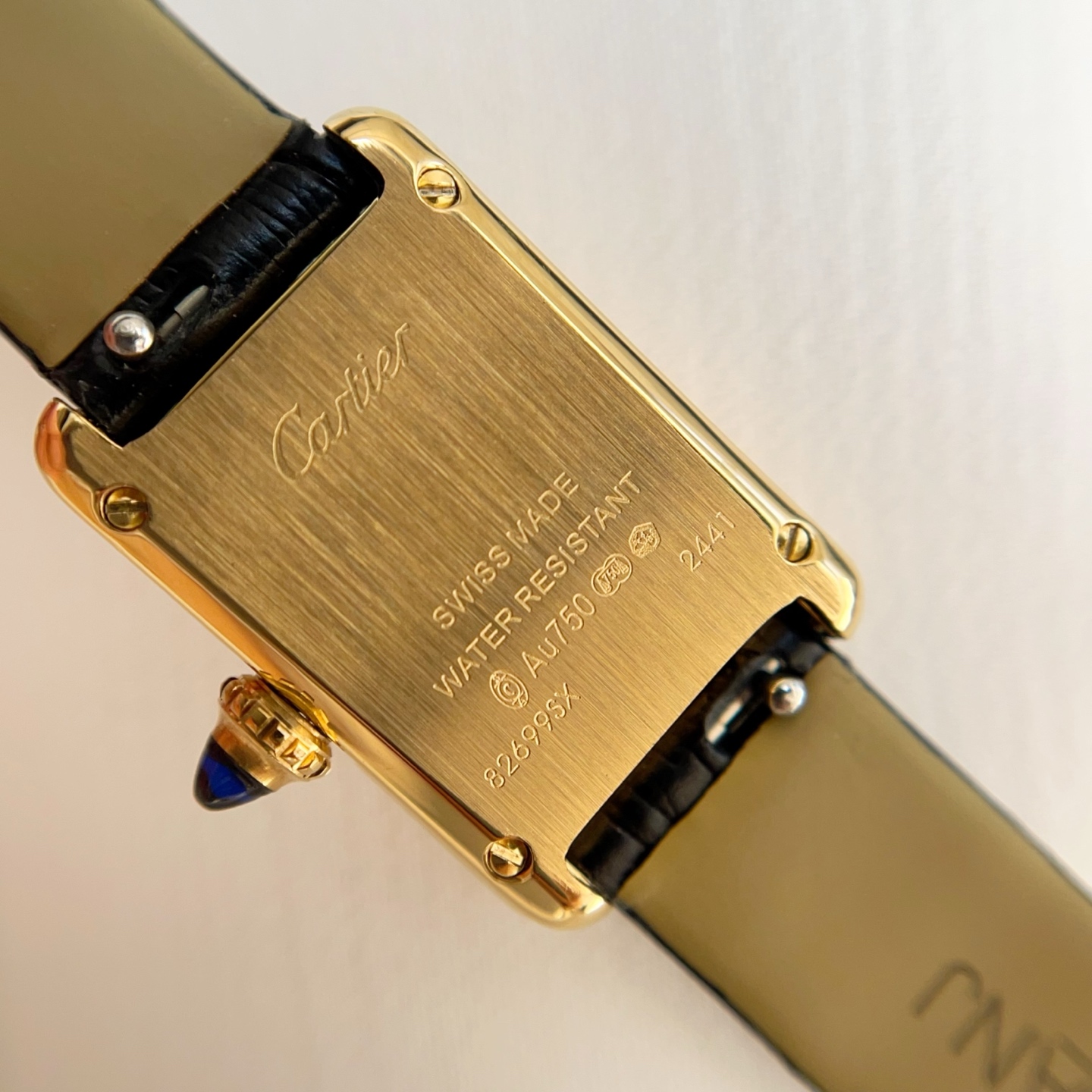 Caseback view of the AF Super Clone Cartier Tank Louis replica watch, showing the gold back and black leather strap.