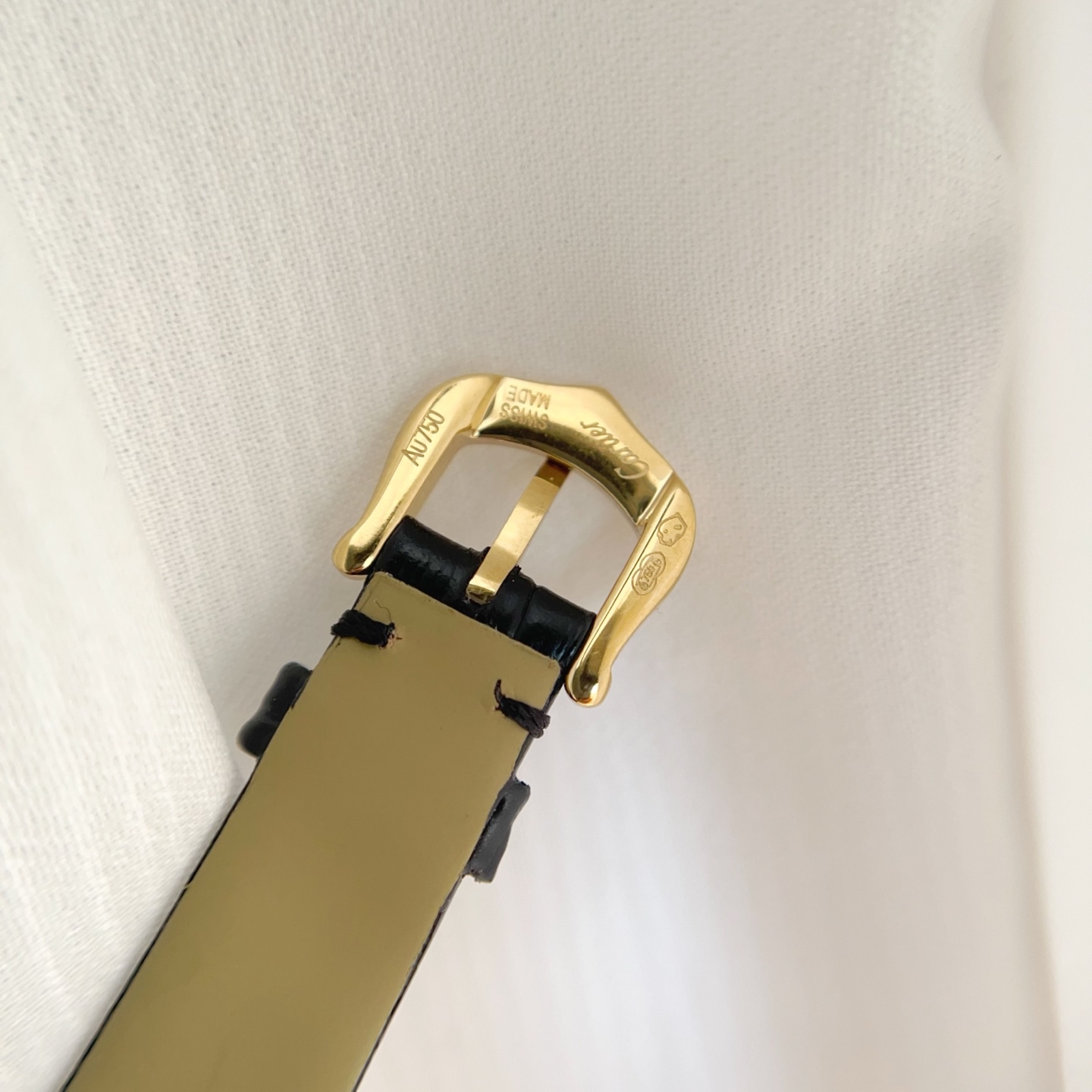 Close-up of the gold buckle of the AF Super Clone Cartier Tank Louis replica watch, with brand engraving.