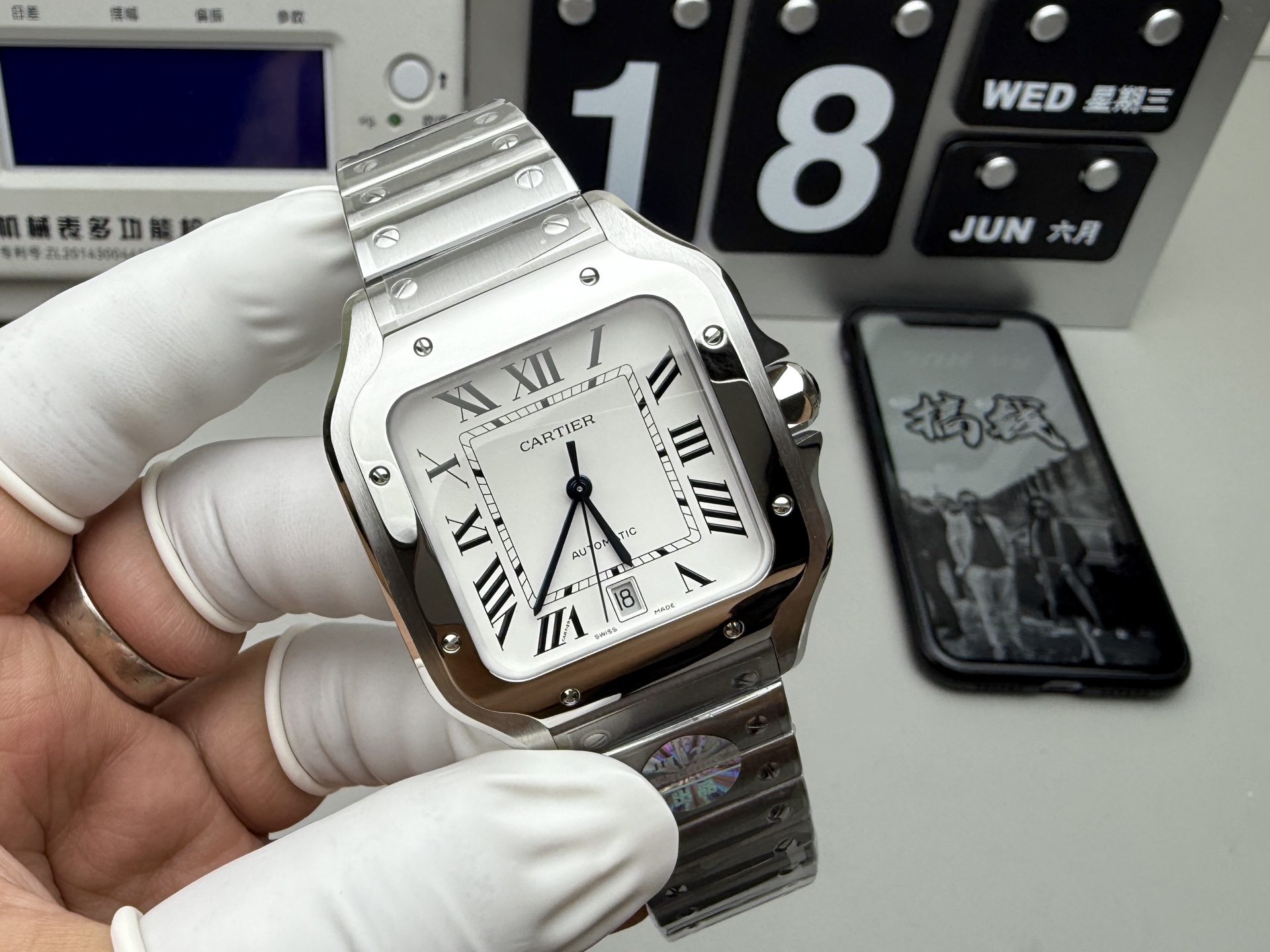 BVF Super Clone Cartier Santos replica watch with a silver case, white dial, date display, and steel bracelet, held by a gloved hand, showing clear dial and bracelet details.